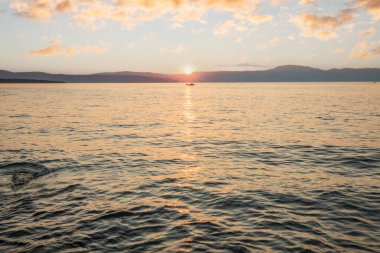 Sahil, gün batımını gören bir liman. Hırvatistan 'ın Krk kentinde deniz manzarası