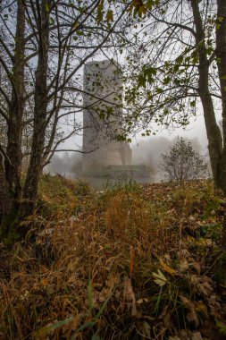 Ruins of a castle. Landscape shot in autumn. Defensive structure in a lake. Misty landscape in the morning at the historical sight in Morbach, Baldenau castle ruins, Rhineland-Palatinate, Germany clipart