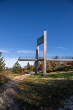 Çelik yolu ve bakış açısı olan ahşap heykel. Dağ manzarası, vadide mavi gökyüzü sisi. Erbeskopf rüzgar ses heykelinde sabah, Hilscheid, Rhineland-Palatinate, Almanya