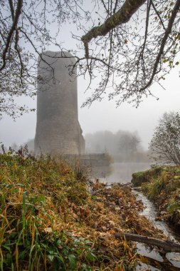 Ruins of a castle. Landscape shot in autumn. Defensive structure in a lake. Misty landscape in the morning at the historical sight in Morbach, Baldenau castle ruins, Rhineland-Palatinate, Germany clipart