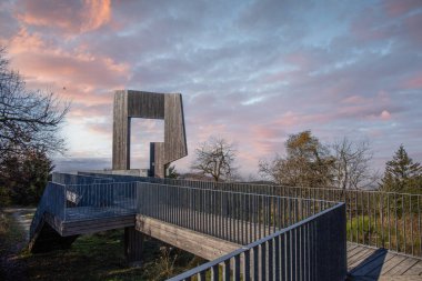 Wooden sculpture with a steel walkway and viewpoint. Landscape shot on a mountain, blue sky fog in the valley. Morning at the Erbeskopf wind sound sculpture, Hilscheid, Rhineland-Palatinate, Germany clipart