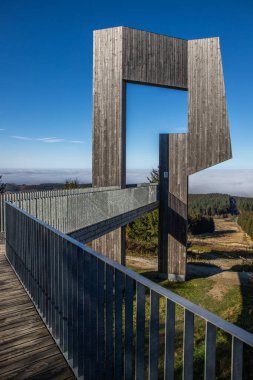 Çelik yolu ve bakış açısı olan ahşap heykel. Dağ manzarası, vadide mavi gökyüzü sisi. Erbeskopf rüzgar ses heykelinde sabah, Hilscheid, Rhineland-Palatinate, Almanya