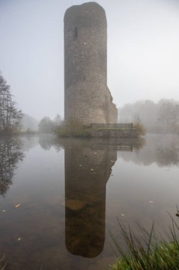 Ruins of a castle. Landscape shot in autumn. Defensive structure in a lake. Misty landscape in the morning at the historical sight in Morbach, Baldenau castle ruins, Rhineland-Palatinate, Germany clipart