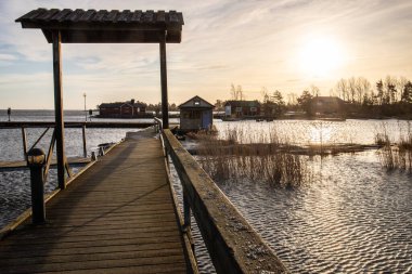 Göl kıyısında, sonbaharda çekilen manzara. İsveç 'teki Sunnana Hamn' da tatil köyü ve liman.
