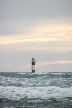 Fırtınada bir deniz feneri duruyor. Uzun vadede vahşi deniz. Kuzey Denizi 'nde birçok kayanın olduğu bir sahilde gün batımı. İsveç, İskandinavya, Avrupa 'da deniz manzarası