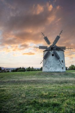 Manzarada ahşap kanatları olan yel değirmeni. Tarlalar, çayırlar ve çiçekler gün batımında belirir. Doğada bir değirmenle çekilmiş manzara. Macaristan 'daki Balaton bölgesi için tarihsel olarak alışılmadık bir durum.