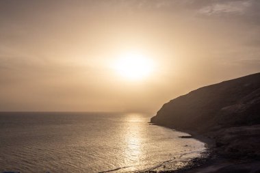 Deniz manzarası var. Küçük bir kasabanın limanındaki şehir plajı. Kumsal ve sahil Gran Tarajal, Las Palmas, Fuerteventura, İspanya