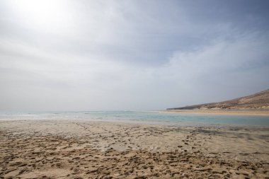 Deniz kenarında sığ bir gölü olan kumlu bir sahil. Akşamları verimsiz manzara çekimleri. Playa de Sotavento de Janda, Fuerteventura, Kanarya Adaları, İspanya