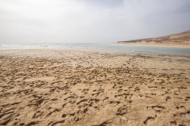 Deniz kenarında sığ bir gölü olan kumlu bir sahil. Akşamları verimsiz manzara çekimleri. Playa de Sotavento de Janda, Fuerteventura, Kanarya Adaları, İspanya