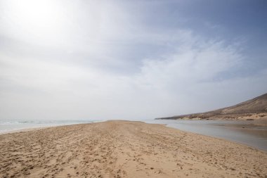 Deniz kenarında sığ bir gölü olan kumlu bir sahil. Akşamları verimsiz manzara çekimleri. Playa de Sotavento de Janda, Fuerteventura, Kanarya Adaları, İspanya