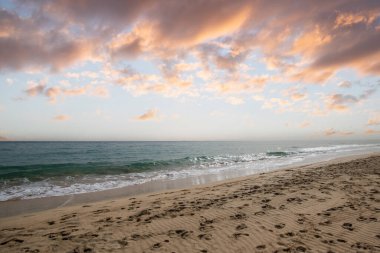 A sandy beach with a shallow lagoon by the sea. Barren landscape shot in the evening. Sandy landscape at the Playa de Sotavento de Janda, Fuerteventura, Canary Islands, Spain clipart