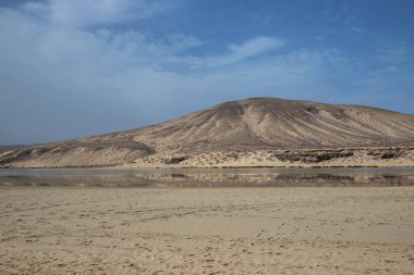 Deniz kenarında sığ bir gölü olan kumlu bir sahil. Akşamları verimsiz manzara çekimleri. Playa de Sotavento de Janda, Fuerteventura, Kanarya Adaları, İspanya