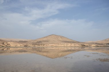 Deniz kenarında sığ bir gölü olan kumlu bir sahil. Akşamları verimsiz manzara çekimleri. Playa de Sotavento de Janda, Fuerteventura, Kanarya Adaları, İspanya