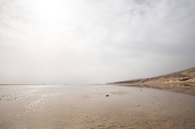 Deniz kenarında sığ bir gölü olan kumlu bir sahil. Akşamları verimsiz manzara çekimleri. Playa de Sotavento de Janda, Fuerteventura, Kanarya Adaları, İspanya