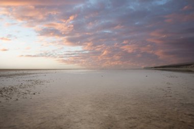 Deniz kenarında sığ bir gölü olan kumlu bir sahil. Akşamları verimsiz manzara çekimleri. Playa de Sotavento de Janda, Fuerteventura, Kanarya Adaları, İspanya