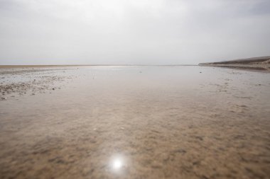 Deniz kenarında sığ bir gölü olan kumlu bir sahil. Akşamları verimsiz manzara çekimleri. Playa de Sotavento de Janda, Fuerteventura, Kanarya Adaları, İspanya