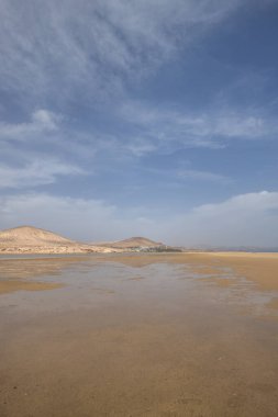 Deniz kenarında sığ bir gölü olan kumlu bir sahil. Akşamları verimsiz manzara çekimleri. Playa de Sotavento de Janda, Fuerteventura, Kanarya Adaları, İspanya
