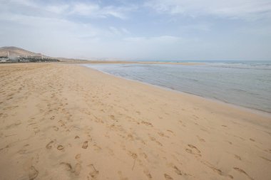 Deniz kenarında sığ bir gölü olan kumlu bir sahil. Akşamları verimsiz manzara çekimleri. Playa de Sotavento de Janda, Fuerteventura, Kanarya Adaları, İspanya