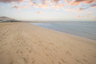 Deniz kenarında sığ bir gölü olan kumlu bir sahil. Akşamları verimsiz manzara çekimleri. Playa de Sotavento de Janda, Fuerteventura, Kanarya Adaları, İspanya