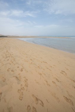 Deniz kenarında sığ bir gölü olan kumlu bir sahil. Akşamları verimsiz manzara çekimleri. Playa de Sotavento de Janda, Fuerteventura, Kanarya Adaları, İspanya