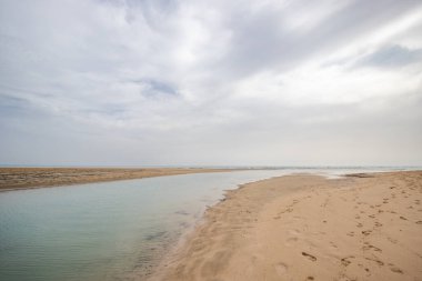 Deniz kenarında sığ bir gölü olan kumlu bir sahil. Akşamları verimsiz manzara çekimleri. Playa de Sotavento de Janda, Fuerteventura, Kanarya Adaları, İspanya