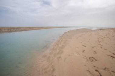 Deniz kenarında sığ bir gölü olan kumlu bir sahil. Akşamları verimsiz manzara çekimleri. Playa de Sotavento de Janda, Fuerteventura, Kanarya Adaları, İspanya