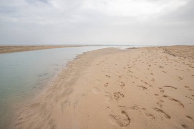 Deniz kenarında sığ bir gölü olan kumlu bir sahil. Akşamları verimsiz manzara çekimleri. Playa de Sotavento de Janda, Fuerteventura, Kanarya Adaları, İspanya