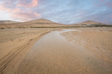 Deniz kenarında sığ bir gölü olan kumlu bir sahil. Akşamları verimsiz manzara çekimleri. Playa de Sotavento de Janda, Fuerteventura, Kanarya Adaları, İspanya