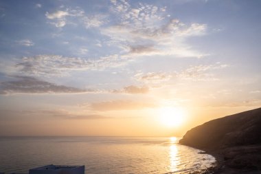 Körfezde gün batımı. Dalgaların çekildiği çorak bir kıyı manzarası olan güzel bir manzara. Hafif bir Calima ile, Gran Tarajal, Kanarya Adaları, Fuerteventura, İspanya 'da büyük gökyüzü renginde alacakaranlık