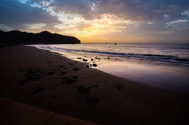 Sabah kumsalda. Güneşin doğuşunda deniz manzarası. Koyun kıyı şeridi, hafif bir kum fırtınası sırasında siyah kumlar, bir Calima. Gran Tarajal, Kanarya Adaları, İspanya
