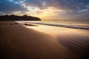 Sabah kumsalda. Güneşin doğuşunda deniz manzarası. Koyun kıyı şeridi, hafif bir kum fırtınası sırasında siyah kumlar, bir Calima. Gran Tarajal, Kanarya Adaları, İspanya