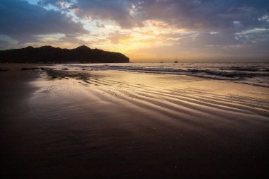 Sabah kumsalda. Güneşin doğuşunda deniz manzarası. Koyun kıyı şeridi, hafif bir kum fırtınası sırasında siyah kumlar, bir Calima. Gran Tarajal, Kanarya Adaları, İspanya