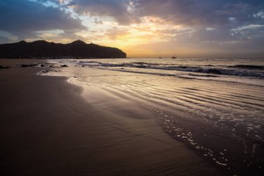 Sabah kumsalda. Güneşin doğuşunda deniz manzarası. Koyun kıyı şeridi, hafif bir kum fırtınası sırasında siyah kumlar, bir Calima. Gran Tarajal, Kanarya Adaları, İspanya