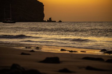 Fırtına sırasında gün doğumu, Calima. Sis kaplı ufuk turuncuya dönerken güneş bir güneş topu gibi doğuyor. Bir tekne denize demir attı. Gran Tarajal 'daki manzara fotoğrafı, Kanarya Adaları, İspanya