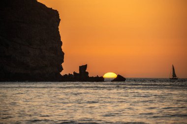 Fırtına sırasında gün doğumu, Calima. Sis kaplı ufuk turuncuya dönerken güneş bir güneş topu gibi doğuyor. Bir tekne denize demir attı. Gran Tarajal 'daki manzara fotoğrafı, Kanarya Adaları, İspanya