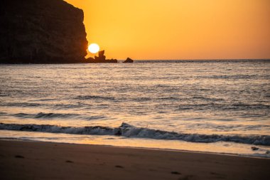 Fırtına sırasında gün doğumu, Calima. Sis kaplı ufuk turuncuya dönerken güneş bir güneş topu gibi doğuyor. Bir tekne denize demir attı. Gran Tarajal 'daki manzara fotoğrafı, Kanarya Adaları, İspanya