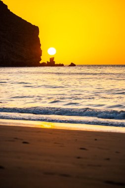 Fırtına sırasında gün doğumu, Calima. Sis kaplı ufuk turuncuya dönerken güneş bir güneş topu gibi doğuyor. Bir tekne denize demir attı. Gran Tarajal 'daki manzara fotoğrafı, Kanarya Adaları, İspanya