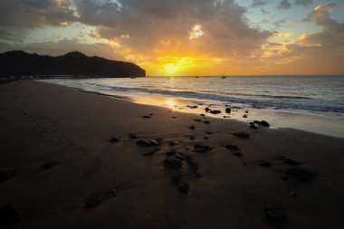 Sabah kumsalda. Güneşin doğuşunda deniz manzarası. Koyun kıyı şeridi, hafif bir kum fırtınası sırasında siyah kumlar, bir Calima. Gran Tarajal, Kanarya Adaları, İspanya