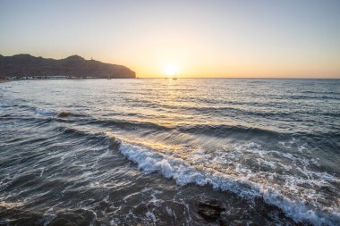 Sabah kumsalda. Güneşin doğuşunda deniz manzarası. Koyun kıyı şeridi, hafif bir kum fırtınası sırasında siyah kumlar, bir Calima. Gran Tarajal, Kanarya Adaları, İspanya