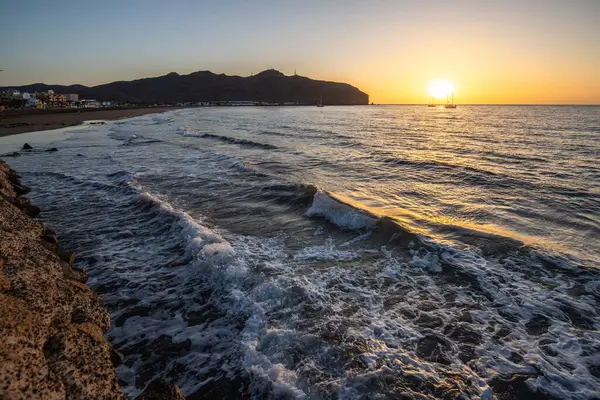 Sabah kumsalda. Güneşin doğuşunda deniz manzarası. Koyun kıyı şeridi, hafif bir kum fırtınası sırasında siyah kumlar, bir Calima. Gran Tarajal, Kanarya Adaları, İspanya