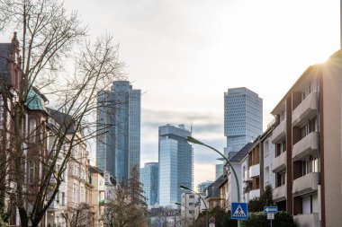 Gün batımında büyük bir şehir. Ufuk çizgisindeki modern binalar. Tarihi binaların önündeki modern mimari. Frankfurt şehrinin sokak fotoğrafı. Ben Main, Almanya.