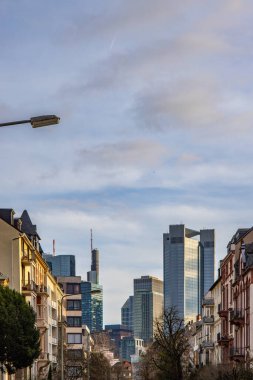Gün batımında büyük bir şehir. Ufuk çizgisindeki modern binalar. Tarihi binaların önündeki modern mimari. Frankfurt şehrinin sokak fotoğrafı. Ben Main, Almanya.