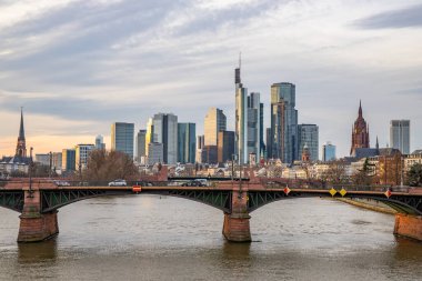 Gün batımında büyük bir şehir. Nehrin ufuk çizgisi üzerinde modern binalar. Yüksek binalar suya yansıtılır. Frankfurt am Main, Almanya 'nın modern mimarisi