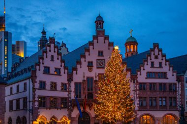 Tarihi bir belediye binasının Noel resmi. Kışın yarı ağaçlı bir evin önünde bir Noel ağacı duruyor. Rmerberg, Frankfurt am Main, Almanya 'dan gece çekimi
