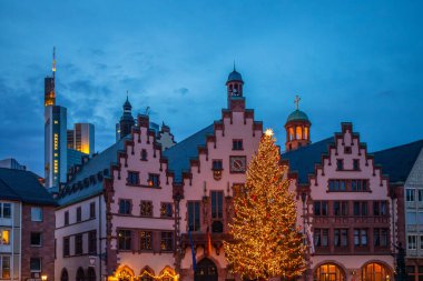 Tarihi bir belediye binasının Noel resmi. Kışın yarı ağaçlı bir evin önünde bir Noel ağacı duruyor. Rmerberg, Frankfurt am Main, Almanya 'dan gece çekimi