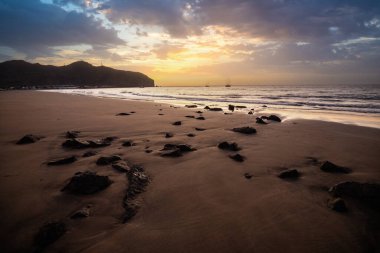 Sabah kumsalda. Güneşin doğuşunda deniz manzarası. Koyun kıyı şeridi, hafif bir kum fırtınası sırasında siyah kumlar, bir Calima. Gran Tarajal, Kanarya Adaları, İspanya