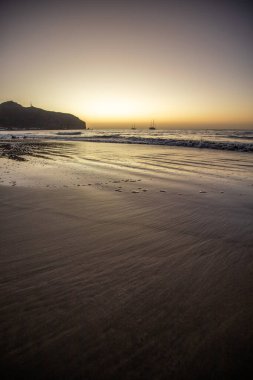 Sabah kumsalda. Güneşin doğuşunda deniz manzarası. Koyun kıyı şeridi, hafif bir kum fırtınası sırasında siyah kumlar, bir Calima. Gran Tarajal, Kanarya Adaları, İspanya