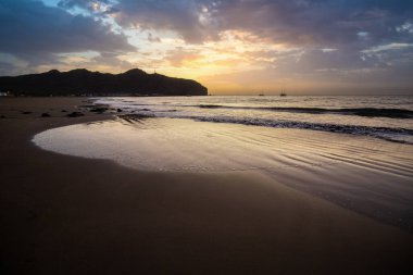 Sabah kumsalda. Güneşin doğuşunda deniz manzarası. Koyun kıyı şeridi, hafif bir kum fırtınası sırasında siyah kumlar, bir Calima. Gran Tarajal, Kanarya Adaları, İspanya