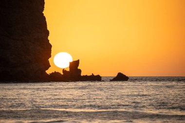 Fırtına sırasında gün doğumu, Calima. Sis kaplı ufuk turuncuya dönerken güneş bir güneş topu gibi doğuyor. Bir tekne denize demir attı. Gran Tarajal 'daki manzara fotoğrafı, Kanarya Adaları, İspanya