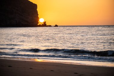 Fırtına sırasında gün doğumu, Calima. Sis kaplı ufuk turuncuya dönerken güneş bir güneş topu gibi doğuyor. Bir tekne denize demir attı. Gran Tarajal 'daki manzara fotoğrafı, Kanarya Adaları, İspanya